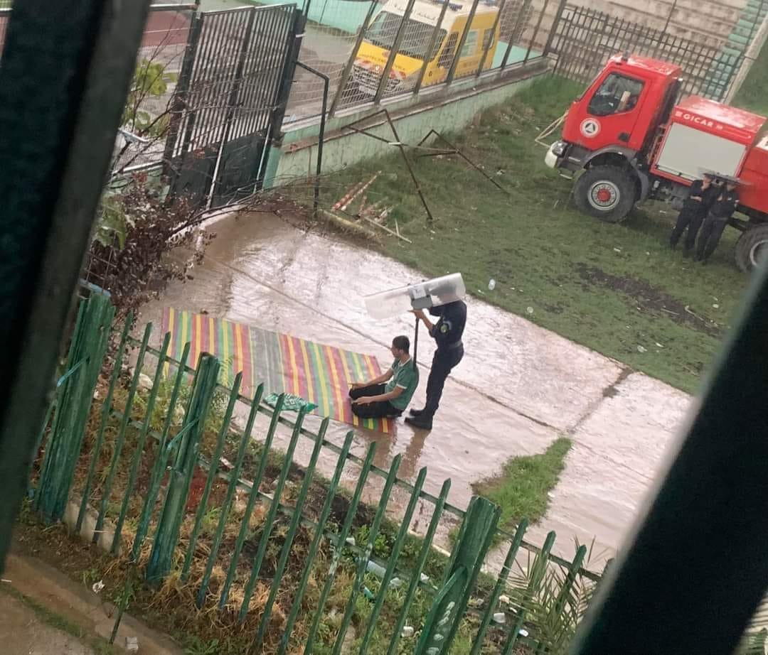 Algérie : un policier protège un supporter de la pluie pendant sa prière, la scène devient virale
